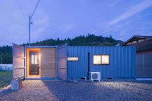 a blue shipping container sitting on top of a garage at Riverside Sauna Base Conpeki in Taniai +65 photos