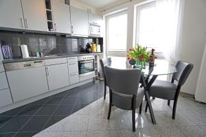 eine Küche mit einem Tisch und Stühlen sowie eine Küche mit weißen Schränken in der Unterkunft Dünenresidenz A05 in Bansin
