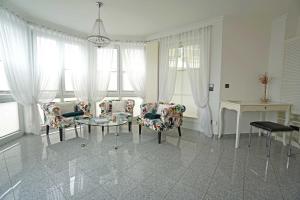 ein Wohnzimmer mit Stühlen und einem Tisch und Fenstern in der Unterkunft Dünenresidenz A05 in Bansin