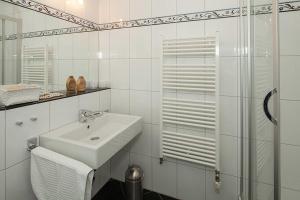 ein weißes Badezimmer mit Waschbecken und Dusche in der Unterkunft Dünenresidenz A05 in Bansin + 1 Foto