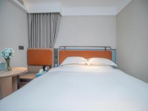 Uma cama ou camas num quarto em Echarm Hotel Qingyuan Qingcheng Station Municipal Government Shop
