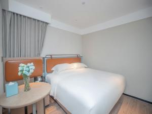 Uma cama ou camas num quarto em Echarm Hotel Qingyuan Qingcheng Station Municipal Government Shop