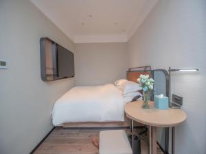Uma cama ou camas num quarto em Echarm Hotel Qingyuan Qingcheng Station Municipal Government Shop