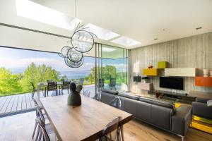 a dining room with a table and a large window at Maison du Golf in Publier
