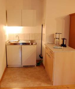 Una pequeña cocina con fregadero y encimera. en Ruegen Fewo 106, en Wiek auf Rügen