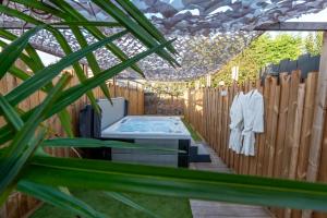 a garden with a table and a fence at Les secrets de la baie - La Romana - évasion relaxante Spa privatif in Étaples