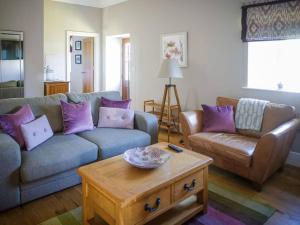 een woonkamer met een bank en een salontafel bij Chic Clock Tower with Gardens Close to Beaches in Johnston