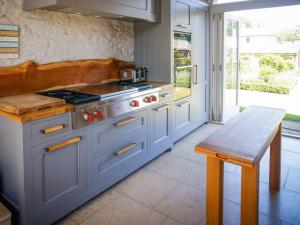 een keuken met een fornuis, een wastafel en een tafel bij Chic Clock Tower with Gardens Close to Beaches in Johnston