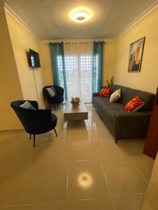 a living room with a couch and chairs and a table at Posada del caribe in La Cana