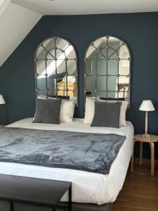 a bedroom with a large bed with two large mirrors at Domaine des Annouillards in Sornac +26 photos