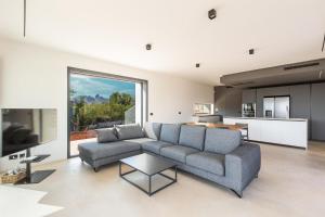 a living room with a couch and a kitchen at Quintessenza by Perle di Puglia in Torre Vado