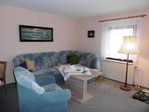 a living room with a blue couch and a table at Ferienwohnung am Bodden in Ralswiek