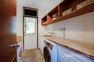 une cuisine avec une machine à laver et un évier dans l'établissement Historical cottage in the hills, à Greenmount