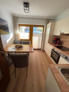 a kitchen with a wooden table and a dining room at Sonnhang Apartment Unterkofler in Sankt Johann im Pongau +12 photos