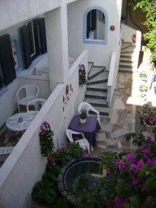 a balcony with a table and some flowers and stairs at Koralli Studios in Korissia