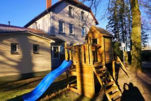a playground with a slide in front of a house at Apartment Pharos in Seevetal