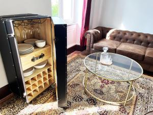 a living room with a table and a refrigerator at Dejean Vintage-wifi-centre-ville-Vélo in Castelnaudary