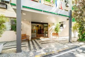 an entrance to a building with two benches under a canopy at Infinity Copacabana in Rio de Janeiro