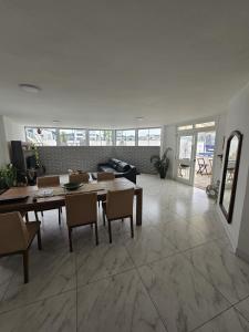 a living room with a table and chairs at Suíte en apartamento privado in Balneário Camboriú