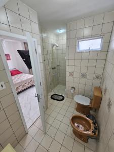 a bathroom with a toilet and a shower at Suíte en apartamento privado in Balneário Camboriú