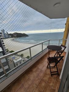 a balcony with a table and a view of the ocean at Suíte en apartamento privado in Balneário Camboriú +26 photos