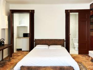 a bedroom with a large bed and a bathroom at Dejean Vintage-wifi-centre-ville-Vélo in Castelnaudary