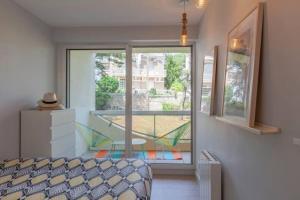 - une chambre avec une fenêtre donnant sur un balcon dans l'établissement Un duplex à la mer, à La Baule