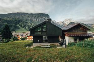 a house on a hill with mountains in the background at Tabia' Stelo Fiorito in Santo Stefano di Cadore