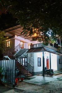 a house with a motorcycle parked in front of it at Marari Moriyah Homestay in Mararikulam