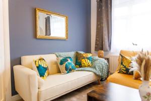 ein Wohnzimmer mit einer Couch und einem Spiegel in der Unterkunft Stylish 6-Bedroom House, Ideal for Contractors! in Monkwearmouth