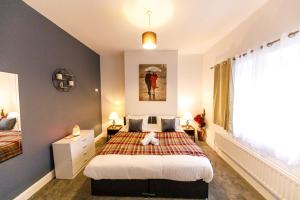 ein Schlafzimmer mit einem Bett und einem großen Fenster in der Unterkunft Stylish 6-Bedroom House, Ideal for Contractors! in Monkwearmouth