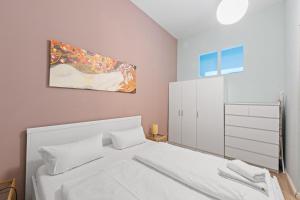 une chambre avec un lit blanc et un tableau au mur dans l'établissement Apartment Uthman Berlin-Neukölln, à Berlin