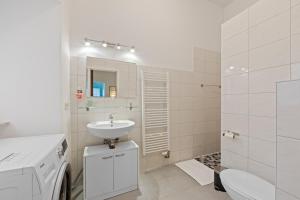une salle de bain blanche avec un lavabo et des toilettes dans l'établissement Apartment Uthman Berlin-Neukölln, à Berlin 3 autres photos