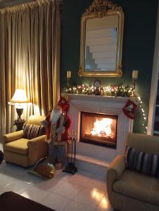 una sala de estar con chimenea y adornos navideños en Three Goods Trikala Meteora, en Tríkala