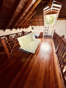 a living room with a couch on a wooden floor at Villa Ti Bwa Kréyol in Rivière-Salée