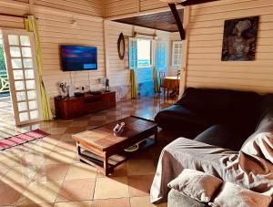 a living room with a couch and a coffee table at Villa Ti Bwa Kréyol in Rivière-Salée
