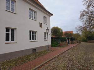a white house with a street light in front of it at Allerhaus Apartments am Ackerbürgerhaus in Verden