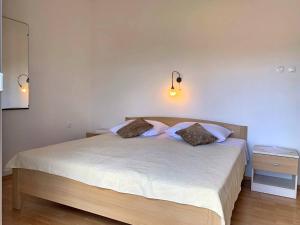 sypialnia z dużym łóżkiem z 2 poduszkami w obiekcie Apartments Nevenka P. w mieście Šilo