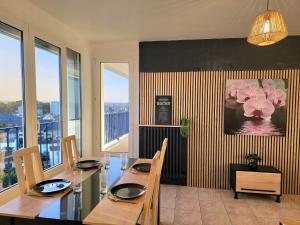 a dining room with a table and some windows at Chambre confort dans Appartement Partagé in Tarbes