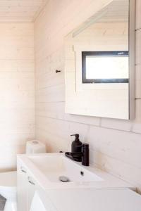 a white bathroom with a sink and a window at Stay North - Armas in Töfsala