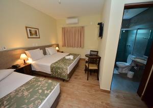 インダイアトゥーバにあるHotel Passaledoのベッド2台とバスルームがあるホテルの部屋