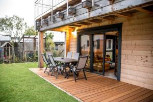 Una terraza de madera con una mesa y sillas. en Erlebe das Black oder Forest, en Offenburg