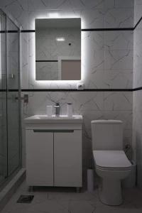 łazienka z toaletą, umywalką i lustrem w obiekcie Merter Apartments w mieście Kawadarci