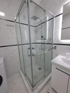 W łazience znajduje się szklana kabina prysznicowa i umywalka. w obiekcie Merter Apartments w mieście Kawadarci +4 zdjęcia