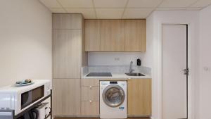 une cuisine avec un lave-linge et un micro-ondes dans l'établissement 314 Suite Monnier - Superb apartment in Paris, à Paris 11 autres photos