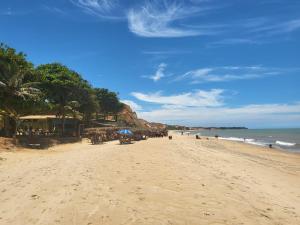 a beach with a crowd of people and the ocean at Casa Marataízes in Marataizes