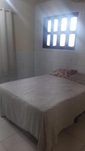 a large bed in a room with a window at Casa Marataízes in Marataizes
