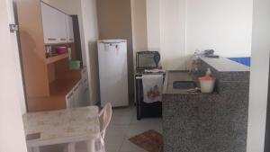 a kitchen with a refrigerator and a chair in it at Casa Marataízes in Marataizes