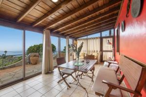 a living room with a table and chairs and a view of the ocean at Apartamentos Los Aljibes in Las Tricias