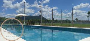 una piscina de agua azul y una montaña en el fondo en Posada LA MARRU, en Paraguarí 6 fotos más